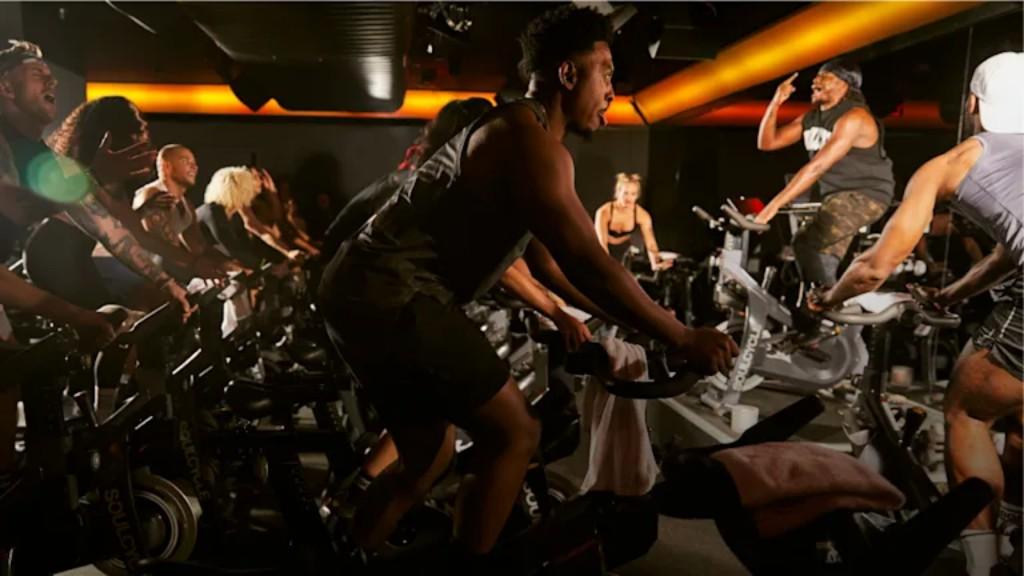 SoulCycle riders in an energetic indoor cycling class